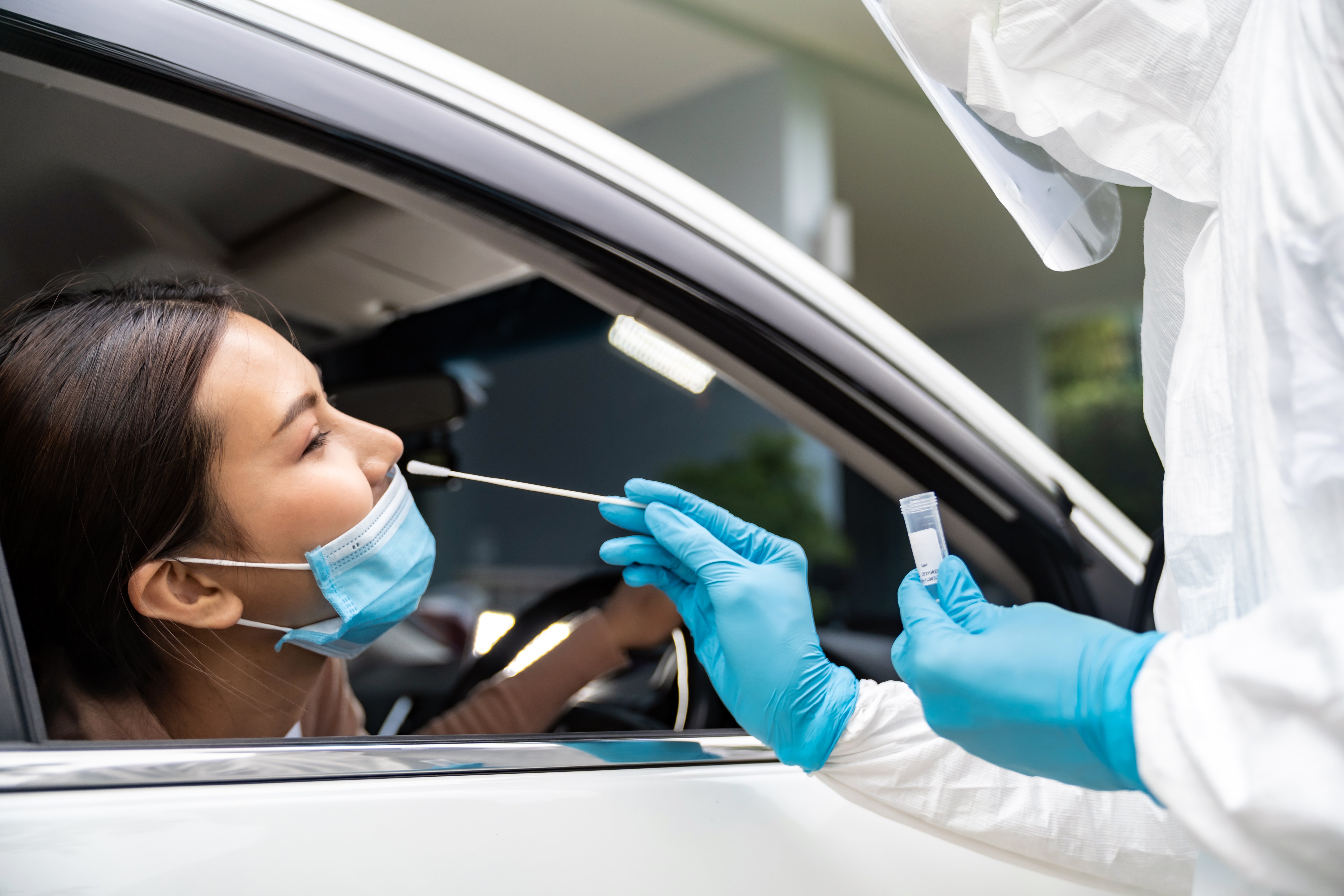 portrait-asian-woman-drive-thru-coronavirus-covid-19-test-by-medical-staff-with-ppe-suit-by-nose-swab-new-normal-health